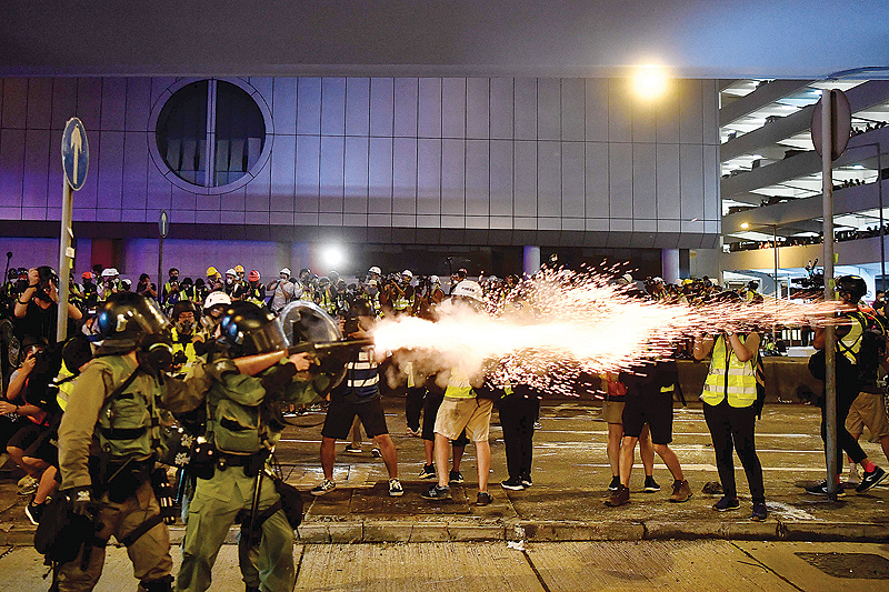 HONG KONG: A policeman fires tear gas at protesters to disperse them after a march against a controversial extradition bill in Hong Kong yesterday. —AFP