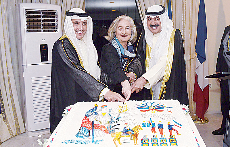 KUWAIT: (From left) Kuwait's Assistant Foreign Minister Sheikh Dr Ahmad Nasser Al-Mohammad Al-Sabah, French Ambassador to Kuwait Marie Masdupuy and Kuwait's Deputy Foreign Minister Khaled Al-Jarallah cut the cake during the French Embassy's national day reception. - KUNA photos