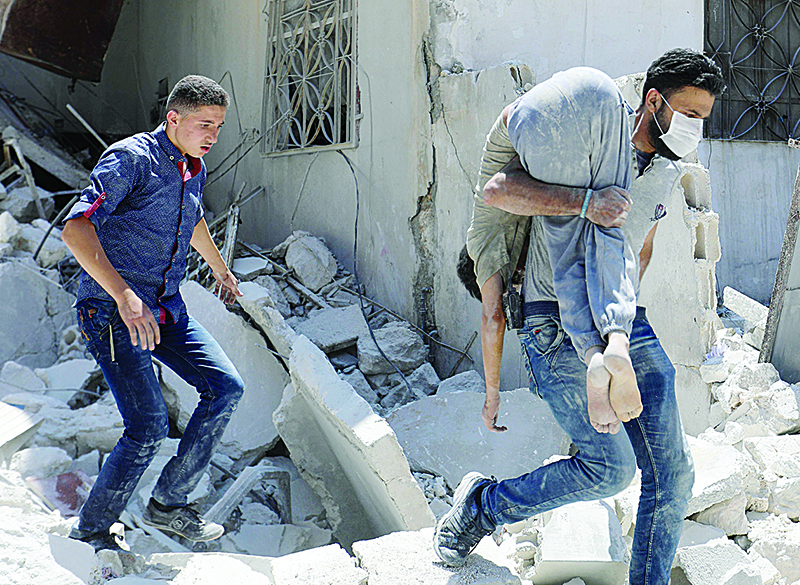 TOPSHOT - A Smember of the Syrian Civil Defence (White Helmets) inspects a victim at the site of a reported air strike on the town of Ariha, in the south of Syria's Idlib province on July 27, 2019. - Regime airstrikes on July 27 killed 10 civilians in northwest Syria, where ramped up attacks by Damascus and its ally Russia have claimed the lives of hundreds since late April. Idlib and parts of the neighbouring provinces of Aleppo, Hama and Latakia are under the control of Hayat Tahrir al-Sham, a jihadist group led by Syria's former Al-Qaeda affiliate. (Photo by Omar HAJ KADOUR / AFP)