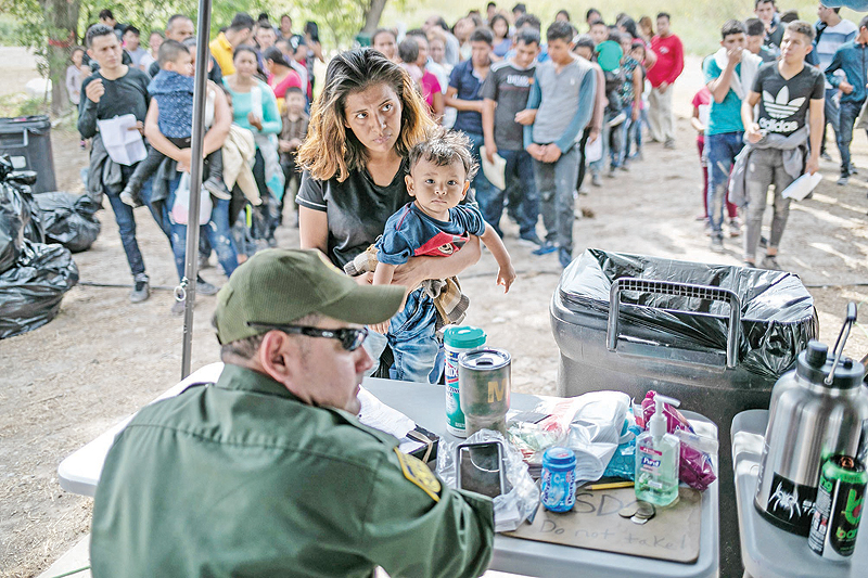 TEXAS: A US Border Patrol agent interviews immigrants after taking them into custody in Los Ebanos, Texas. — AFP