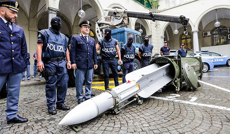 Police stand by a missile seized at an airport hangar near Pavia, northern Italy - AP