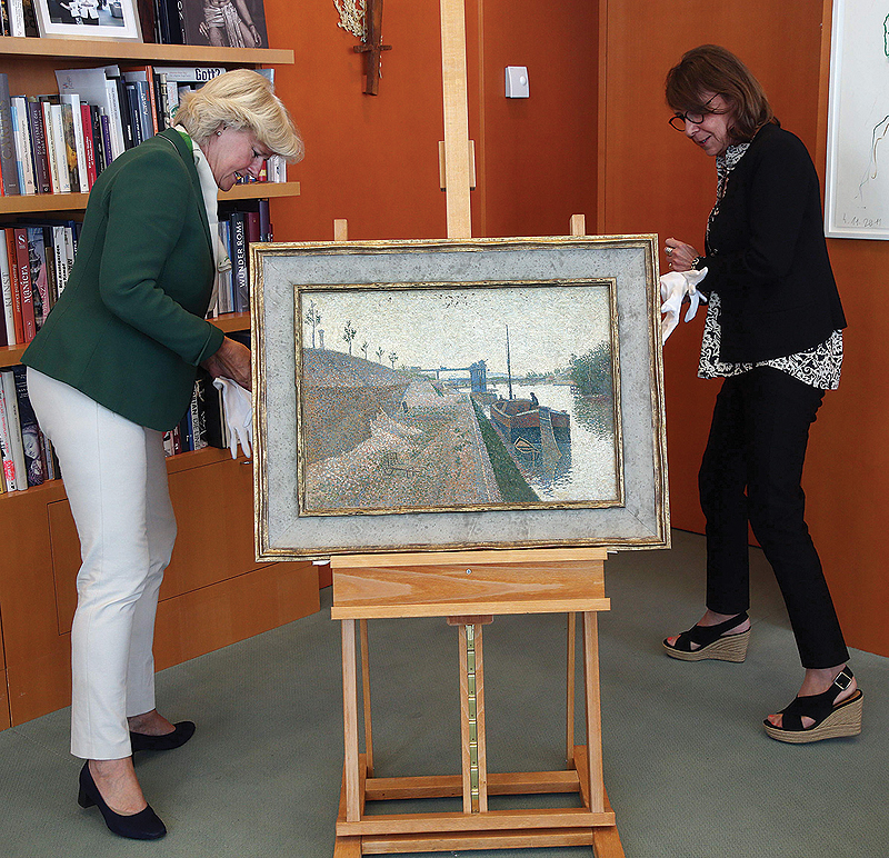 German Government’s Commissioner for Culture and the Media Monika Gruetters hands over the painting “Quai de Clichy” by French Neo-Impressionist Paul Signac to Agnes Sevestre-Barbe, representative of the heiress. — AFP
