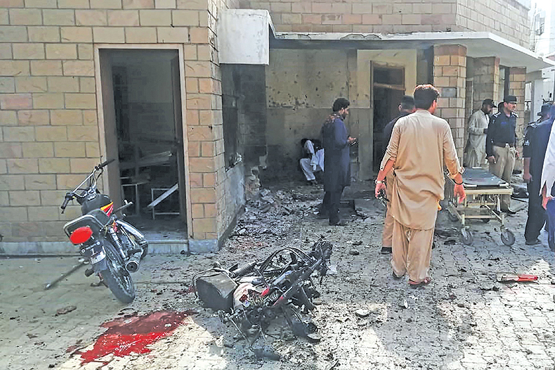 DERA ISMAIL KHAN: Pakistani security officials examine the site of a suicide bomb attack at the entrance of a hospital in Kotlan Saidan village on the outskirts of the northwestern city of Dera Ismail Khan yesterday. — AFP