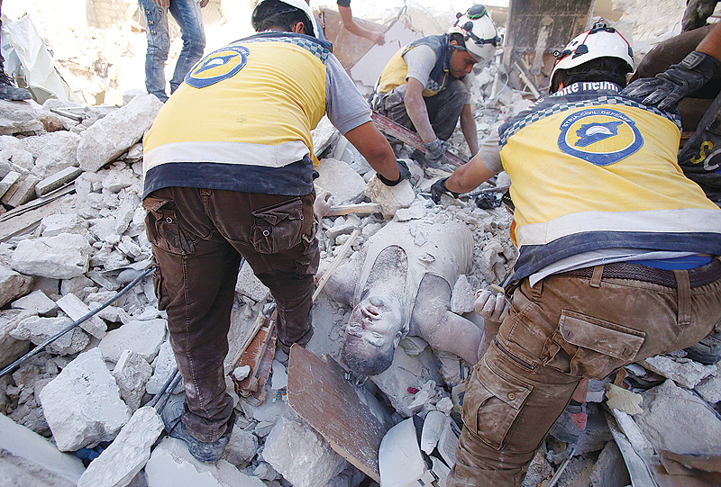 MAARET AL-NUMAN, Syria: Members of the Syrian civil defense, known as the White Helmets, pull a victim out of the rubble of a building following reported air strikes by pro-regime forces on Maaret al-Numan in Syria’s northwestern Idlib province. —AFP