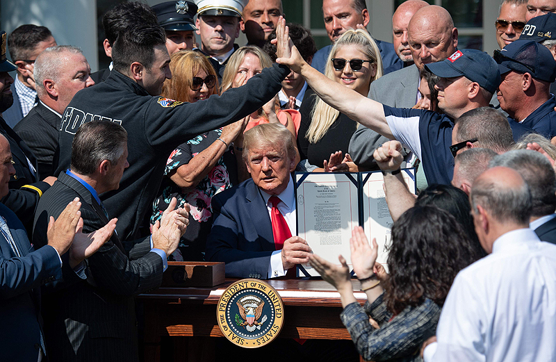 WASHINGTON: People applaud as US President Donald Trump, surrounded by Sept 11 first responders and family members, signs an act to permanently authorize the Sept 11 victim compensation fund during a ceremony in the Rose Garden of the White House yesterday. - AFP 