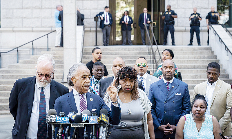 NEW YORK: Rev Al Sharpton (2nd from left) speaks as Gwen Carr (center), mother of the late Eric Garner, looks on during a press conference outside the US Attorney’s office following a meeting with federal prosecutors in the Brooklyn borough. — AFP