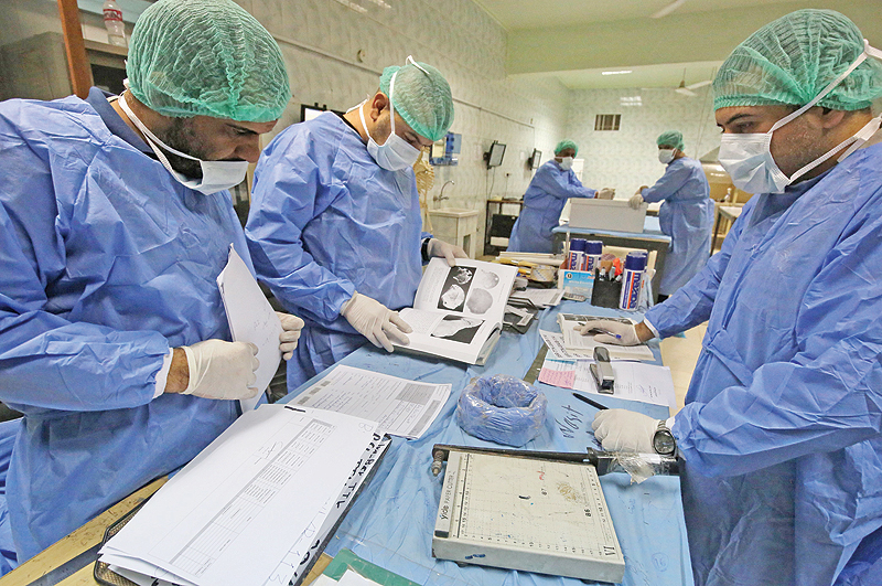 BAGHDAD: Staff at Iraqi forensics lab Medico-Legal Directorate in eastern Baghdad inspect samples. The bones, recently exhumed from mass graves in the Yazidi stronghold of Sinjar in northwest Iraq, will be compared with blood samples from surviving members of the community to help determine the fates of those still missing after the Islamic State group’s 2014 sweep across their villages. — AFP