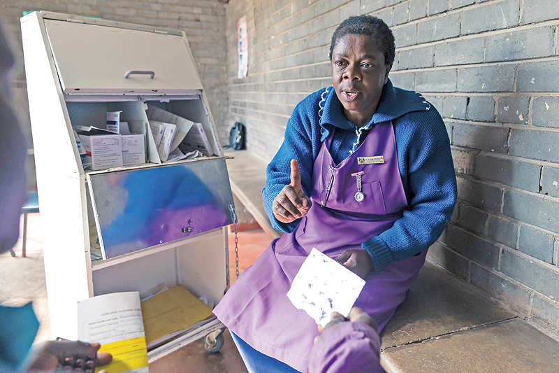 HARARE: Nurse Angela Chikondo instructs Blessing Chingwaru, 29, an HIV positive TB patient on how he should take medication received as part of his treatment at Rutsanana Polyclinic in Glen Norah township, Harare. — AFP