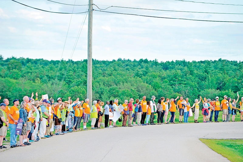 Marchers wave to detainees in the prison as they go by Strafford County Detention Center, where ICE detainees are being held, in Dover on August 24, 2019 during the New Hampshire Immigrant Solidarity Walk for Justice organized by Granite State and the New Hampshire council of Churches. - Religious groups from Massachusetts, Vermont, New Hampshire and Maine completed a multi-day march that culminated in a total of 280 miles (450kms) from their various starting points to the Strafford County Detention Center where ICE detainees are being held in Dover. The groups were protesting the detention and arrest of immigrants in the US. The center is holding 95 immigrants as of two weeks ago, 87 men and 8 women. (Photo by JOSEPH PREZIOSO / AFP)