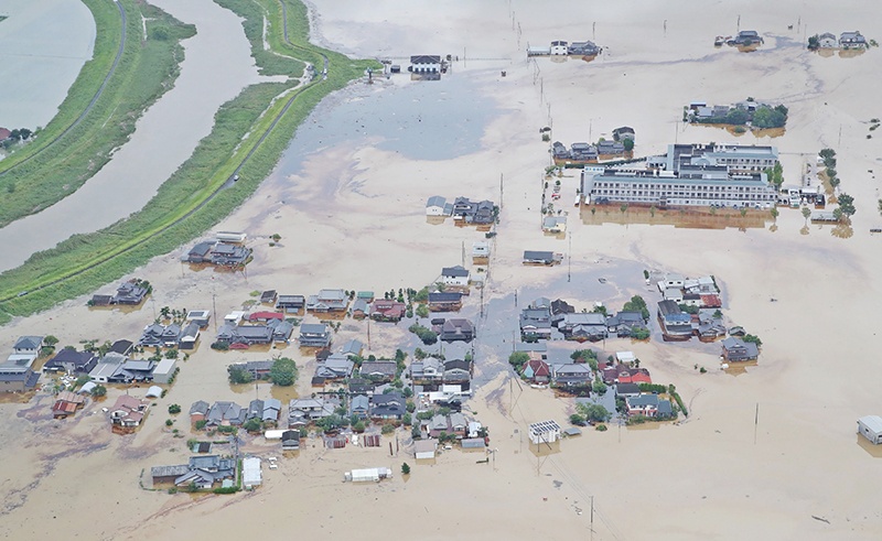TOPSHOT - An aerial view shows submerged houses and buildings following heavy rains in Omachi, Saga prefecture on August 28, 2019. - Two people were confirmed dead as heavy rains pounded southwest Japan, prompting flood and landslide warnings and orders for 670,000 people to seek safety. (Photo by JIJI PRESS / JIJI PRESS / AFP) / Japan OUT