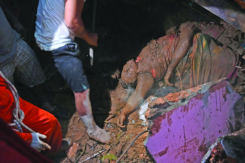 TOPSHOT - EDITORS NOTE: Graphic content / The body of a landslide victim is seen in Paung township, Mon state on August 9, 2019. - A landslide caused by heavy monsoon rains killed at least 13 people and injured dozens more in eastern Myanmar, officials said on August 9, as floods forced tens of thousands across the country to flee their homes. (Photo by Ye Aung THU / AFP)