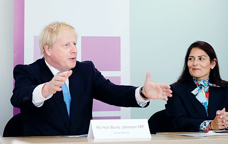 LONDON: Britain’s Prime Minister Boris Johnson (left), accompanied by Britain’s Home Secretary Priti Patel, speaks at the first meeting of the National Policing Board at the Home Office in London. —AFP