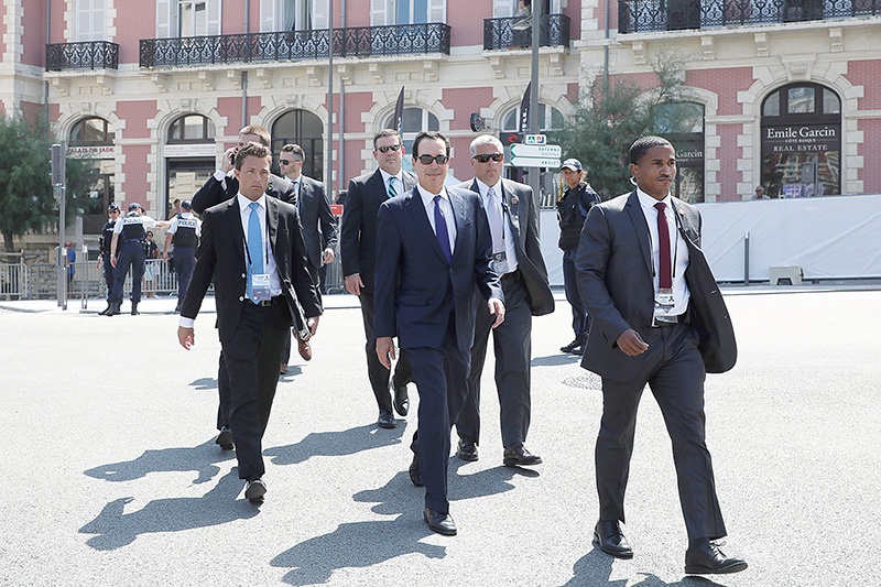 US Secretary of Treasury Steven Mnuchin (C) walks with security personnel in Biarritz, south-west France on August 24, 2019, on the first day of the annual G7 Summit attended by the leaders of the world's seven richest democracies, Britain, Canada, France, Germany, Italy, Japan and the United States. (Photo by ludovic MARIN / AFP)