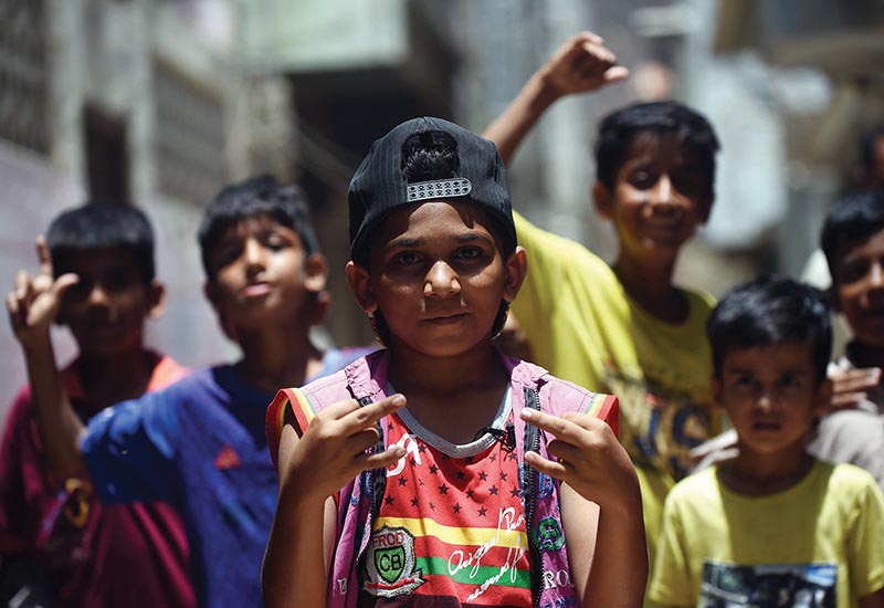 In this picture taken on May 19, 2019, eight-year-old rapper Waqas Baloch (C) gestures as he performs in Lyari, one of Pakistanís most dangerous neighbourhoods, in Karachi. - Haunted by gang violence and poverty for decades, Lyari is considered one of Pakistan's most dangerous areas, but its grim realities have inspired a generation of new artists and spawned a burgeoning hip hop scene. (Photo by RIZWAN TABASSUM / AFP) / To go with 'PAKISTAN-KARACHI-UNREST-MUSIC-LYARI,FEATURE' by David STOUT
