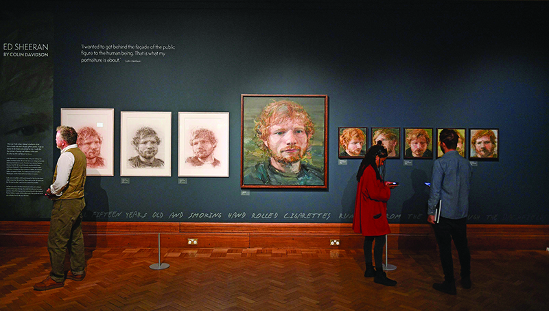 TOPSHOT - Portraits of British musician Ed Sheeran, painted by Irish artist Colin Davidson, are pictured on display during a press preview of the exhibition 'Ed Sheeran: Made in Suffolk' in Ipswich, east England on August 19, 2019. - Ipswich, in eastern England has historically prided itself on farming and football, but is now celebrating the stellar pop career of its most famous son, Ed Sheeran. The global hit machine's journey to stardom began in the nearby town of Framlingham, where he played his first gig in front of around 30 people. (Photo by Daniel LEAL-OLIVAS / AFP) / RESTRICTED TO EDITORIAL USE - MANDATORY MENTION OF THE ARTIST UPON PUBLICATION - TO ILLUSTRATE THE EVENT AS SPECIFIED IN THE CAPTIONnTO GO WITH AFP STORY by Pauline Froissart