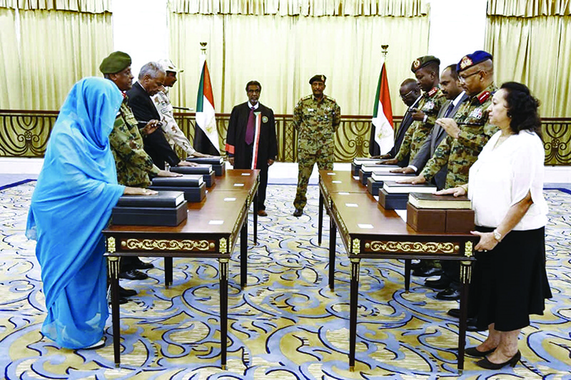A picture released by Sudan's Presidential Palace shows General Abdel Fattah al-Burhan (C-R), the head of Sudan's ruling military council, standing during a swearing in of the new sovereign council, in Khartoum on August 21, 2019. - Sudan took further steps in its transition towards civilian rule today with the swearing in of a new sovereign council, to be followed by the appointment of a prime minister. The body replaces the Transitional Military Council (TMC) that took charge after months of deadly street protests brought down longtime ruler Omar al-Bashir in April. Burhan, who already headed the TMC, was sworn in as the chairman of the new sovereign council in the morning. (Photo by - / SUDAN PRESIDENTIAL PALACE / AFP)
