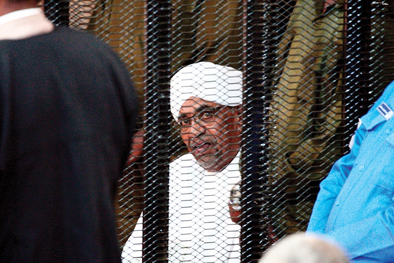 Sudan's deposed military ruler Omar al-Bashir sits in a defendant's cage during his corruption trial in Khartoum on August 24, 2019. (Photo by Ebrahim HAMID / AFP)