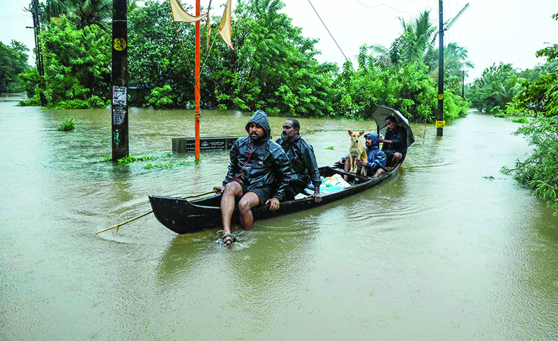 TOPSHOT - Residents are being evacuated from their home to a safer place following floods warnings, on a wooden boat in Kochi in the Indian state of Kerala on August 10, 2019. - Floods have killed at least 100 people and displaced hundreds of thousands across much of India with the southern state of Kerala worst hit, authorities said on August 10. (Photo by STR / AFP)