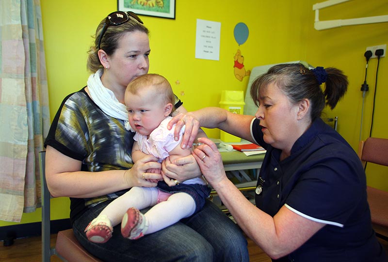 (FILES) In this file photo taken on April 20, 2013 14-month-old Amelia Down sits on the lap of her mother Helen (L) as she receives the combined Measles Mumps and Rubella (MMR) vaccination at an MMR drop-in clinic at Neath Port Talbot Hospital near Swansea in south Wales on April 20, 2013. - Measles cases are skyrocketing in Europe and the disease is surging in four countries previously considered to have eliminated it, including Britain, the World Health Organization (WHO) warned on August 29, 2019, urging countries to step up vaccination efforts. (Photo by GEOFF CADDICK / AFP)