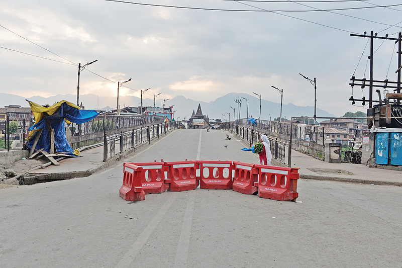 KASHMIR: A woman walks on a deserted street during a curfew in Srinagar yesterday. India’s home affairs minister has hailed “historic” legislation to bring Kashmir under its direct control, as New Delhi stepped up its clampdown on dissent in the restive Muslim-majority region. — A