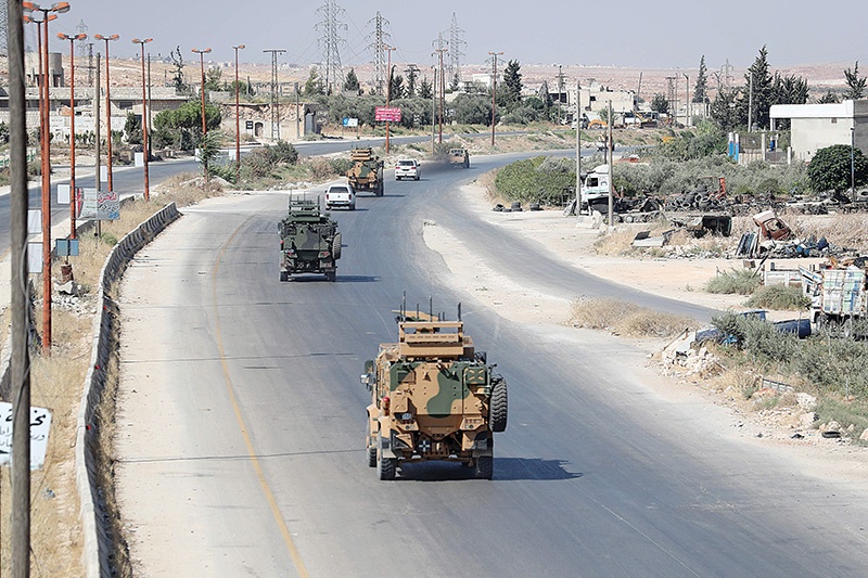 Turkish military vehicles drive down a road in Syria's northern province of Idlib on August 26, 2019. - In northwest Syria, regime forces have in recent days chipped away at the jihadist-dominated region of Idlib on the Turkish border after months of deadly bombardment. (Photo by Omar HAJ KADOUR / AFP)