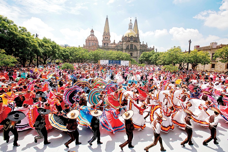 TOPSHOT - Couples dance to Mariachi traditional music to break the Guinness World Record of largest Mexican folk dance in Guadalajara, Jalisco state, Mexico, on August 24, 2019. - 882 people danced to Mariachi music at the start of the 26th Mariachi International Festival. (Photo by Ulises Ruiz / AFP)