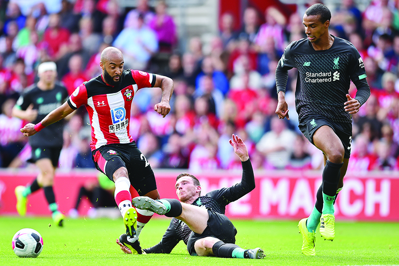 Southampton's English midfielder Nathan Redmond (L) vies with Liverpool's Scottish defender Andrew Robertson (C) as Liverpool's German-born Cameroonian defender Joel Matip (R) looks on during the English Premier League football match between Southampton and Liverpool at St Mary's Stadium in Southampton, southern England on August 17, 2019. (Photo by Glyn KIRK / AFP) / RESTRICTED TO EDITORIAL USE. No use with unauthorized audio, video, data, fixture lists, club/league logos or 'live' services. Online in-match use limited to 120 images. An additional 40 images may be used in extra time. No video emulation. Social media in-match use limited to 120 images. An additional 40 images may be used in extra time. No use in betting publications, games or single club/league/player publications. /