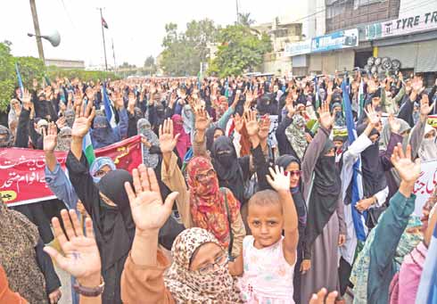 KARACHI: Women supporters of the Pakistani political and Islamic party Jammat-e-Islami (JI) raise their hands during an anti-Indian protest rally in Karachi yesterday. — AFP