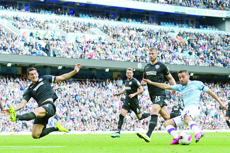 Manchester City's Portuguese midfielder Bernardo Silva (R) shoots past Brighton's English defender Lewis Dunk (L) to score their fourth goal during the English Premier League football match between Manchester City and Brighton and Hove Albion at the Etihad Stadium in Manchester, north west England, on August 31, 2019. (Photo by Lindsey Parnaby / AFP) / RESTRICTED TO EDITORIAL USE. No use with unauthorized audio, video, data, fixture lists, club/league logos or 'live' services. Online in-match use limited to 120 images. An additional 40 images may be used in extra time. No video emulation. Social media in-match use limited to 120 images. An additional 40 images may be used in extra time. No use in betting publications, games or single club/league/player publications. /