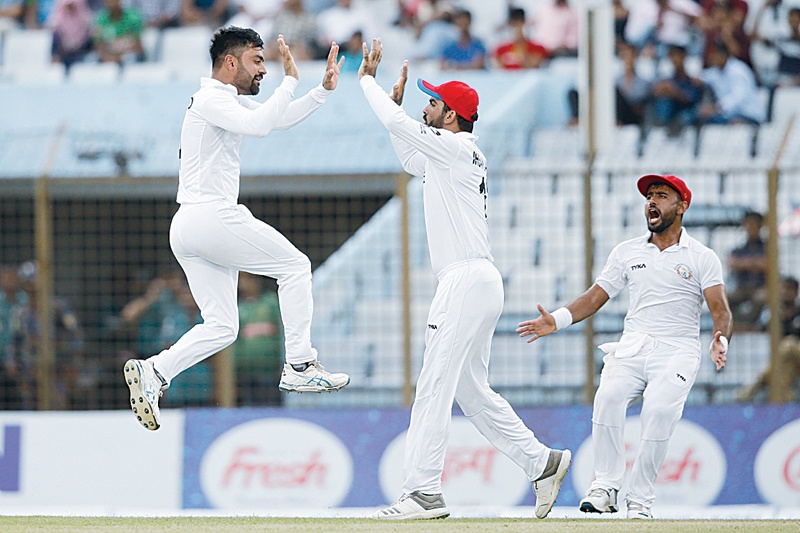 CHITTAGONG: Afghanistan cricketer Rashid Khan (L) celebrates with his teammates after the dismissal of Bangladesh cricketer Musfiqur Rahim during the fourth day of the one-off cricket Test match between Bangladesh and Afghanistan at the Zohur Ahmed Chowdhury Stadium in Chittagong yesterday. —AFP