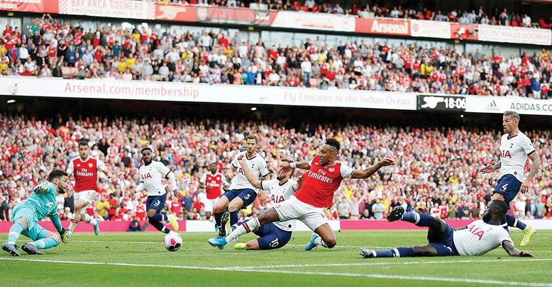LONDON: Arsenal's Gabonese striker Pierre-Emerick Aubameyang (C) tries to direct the ball toward goal past Tottenham Hotspur's French goalkeeper Hugo Lloris (L) but Arsenal's Greek defender Sokratis Papastathopoulos (2nd L) puts in in the net though goal disallowed after a VAR (Video Assistant Referee) review during the English Premier League football match between Arsenal and Tottenham Hotspur at the Emirates Stadium in London yesterday. —AFP