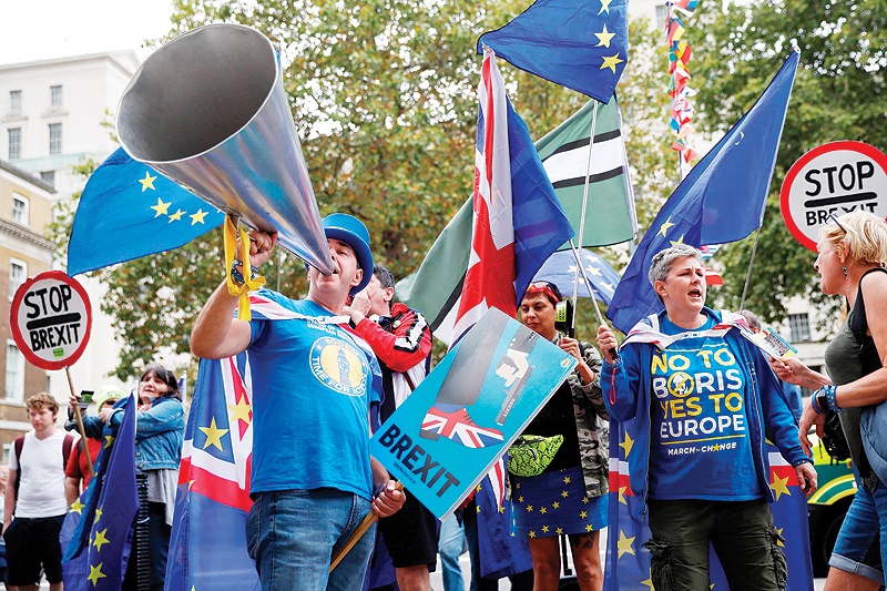 LONDON: Anti-Brexit campaigner Steve Bray (left) and pro-EU protesters gather outside the cabinet office on Whitehall in London yesterday. — AFP