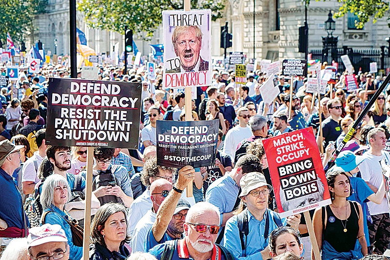 LONDON: Demonstrators hold up placards in the sunshine at a protest against the move to suspend parliament in the final weeks before Brexit outside Downing Street in London.—AFP