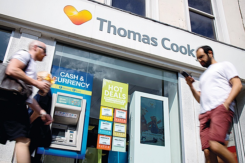 (FILES) In this file photo taken on July 12, 2019 pedestrians walk past a branch of a Thomas Cook travel agent's shop in London. - Tour operator Thomas Cook has confirmed it is seeking £200 million in extra funding as it attempts to prevent a collapse on September 20, 2019 (Photo by Tolga Akmen / AFP)