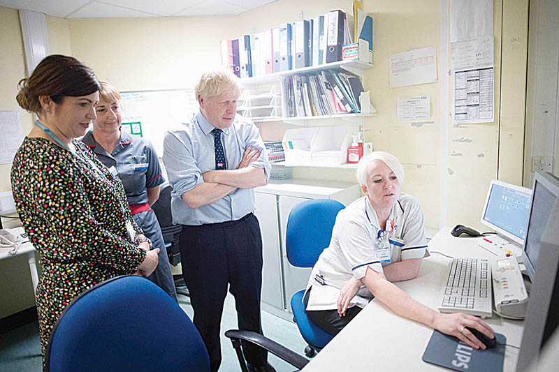Britain's Prime Minister Boris Johnson reacts as he talks with staff during his visit to The Princess Alexandra hospital in Harlow, north of London, on September 27, 2019. - British Prime Minister Boris Johnson suffered yet another setback on Thursday after MPs rejected a request to briefly suspend business for his party's conference, highlighting the hostility he faces in parliament just weeks before Brexit. In his seventh successive defeat in parliament, MPs voted to reject his call for three days off next week to hold his Conservative party's annual conference. (Photo by Stefan Rousseau / POOL / AFP)