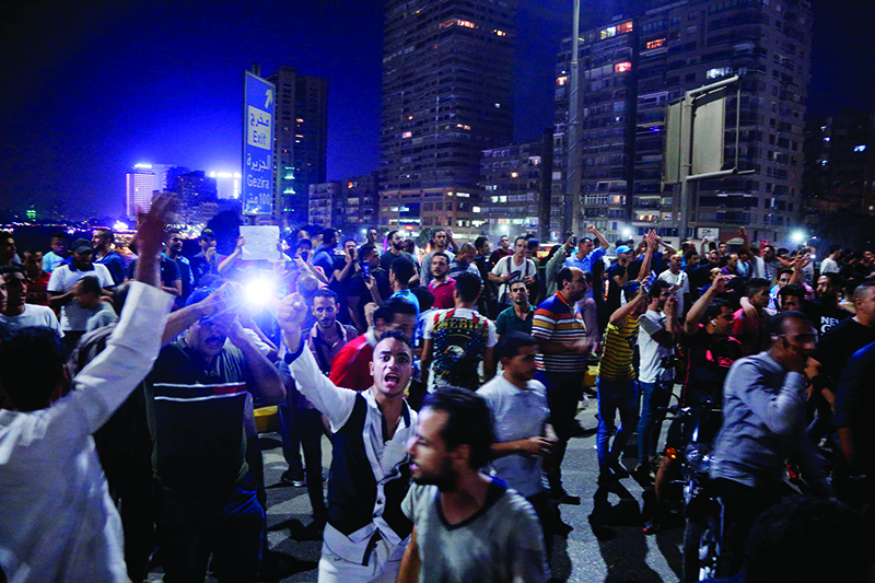 Egyptian protesters shout slogans as they take part in a protest calling for the removal of President Abdel Fattah al-Sisi in Cairo's downtown on September 20, 2019. - Protestors also gathered in other Egyptian cities calling for the removal of President Abdel Fattah al-Sisi but police quickly dispersed them. In Cairo dozens of people joined night-time demonstrations around Tahrir Square -- the epicenter of the 2011 revolution that toppled the country's long-time autocratic leader. (Photo by STR / AFP)