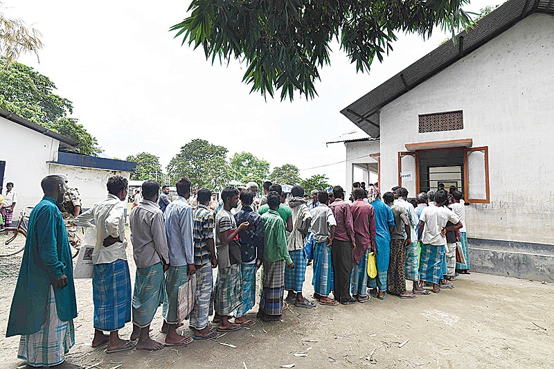 ASSAM: People stand in a queue to check their names on the final list of the National Register of Citizens (NRC) in an office in Pavakati village of Morigoan district, some 70 kms from Guwahati, the capital city of India’s northeastern state of Assam. —AFP