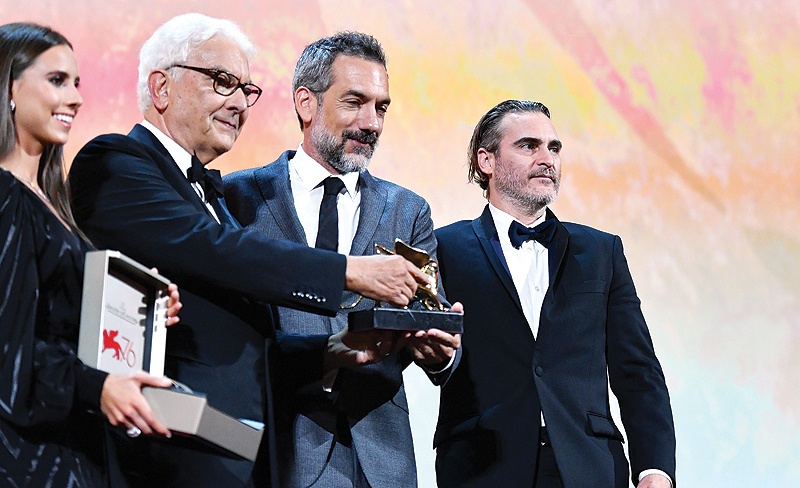 US director Todd Phillips (second right), flanked by US actor Joaquin Phoenix (right) and President of the Venice Biennale Paolo Baratta, holds the Golden Lion award for Best Film he received for the movie ‘Joker’ during the awards ceremony of the 76th Venice Film Festival