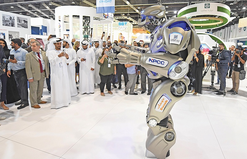 ABU DHABI: Attendees take pictures of a robot during the opening ceremony of the 24th World Energy Congress (WEC) in the UAE capital. — AFP