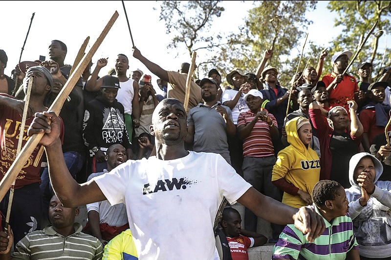 JOHANNESBURG: Zulu residents of the Jeppe Men Hostel scream waving batons in the Johannesburg CBD yesterday after South Africa’s financial capital was hit by a new wave of anti-foreigner violence. — AFP