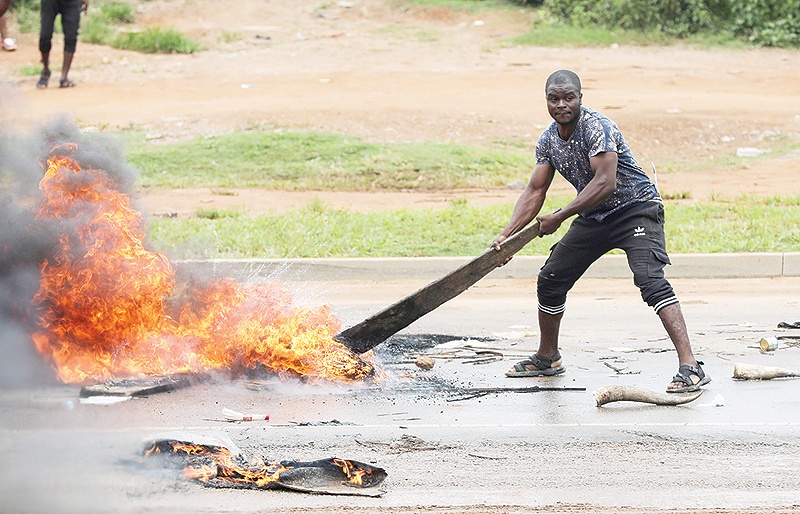 ABUJA: A man tries to set a bonfire on the road during a demonstration and attacks against South Africa’s owned shops. — AFP