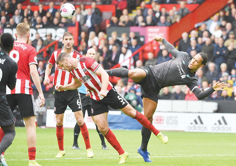 Sheffield United's English defender Jack O'Connell (L) and Liverpool's Dutch defender Virgil van Dijk (R) go for the ball during the English Premier League football match between Sheffield United and Liverpool at Bramall Lane in Sheffield, northern England on September 28, 2019. (Photo by Paul ELLIS / AFP) / RESTRICTED TO EDITORIAL USE. No use with unauthorized audio, video, data, fixture lists, club/league logos or 'live' services. Online in-match use limited to 120 images. An additional 40 images may be used in extra time. No video emulation. Social media in-match use limited to 120 images. An additional 40 images may be used in extra time. No use in betting publications, games or single club/league/player publications. /