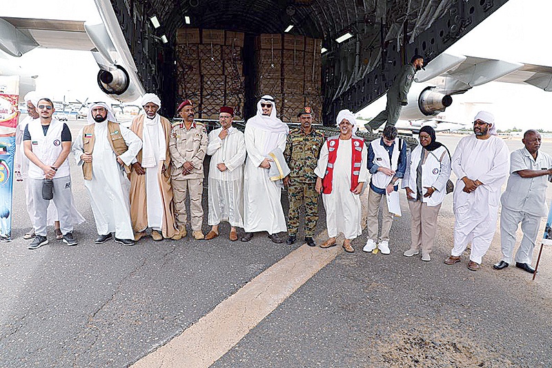 Kuwaiti and Sudanese officials pose for a group picture after the Kuwaiti relief plane’s arrival in Khartoum