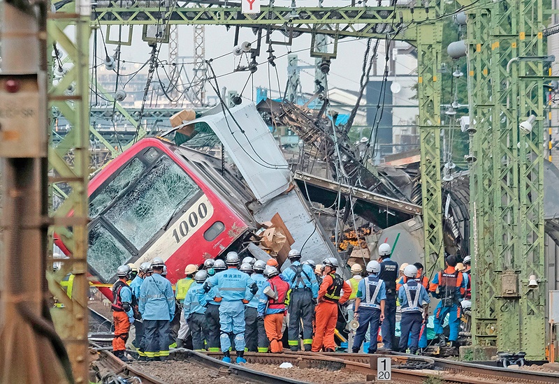 YOKOHAMA: A train is seen derailed after a collision with a truck at a crossing in Yokohama, Kanagawa Prefecture. — AFP
