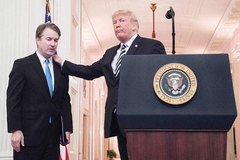 WASHINGTON: In this file photo US President Donald Trump, right, pats Associate Justice of the US Supreme Court Brett Kavanaugh, left, on the back during a ceremonial swear-in at the White House in Washington, DC. — AFP
