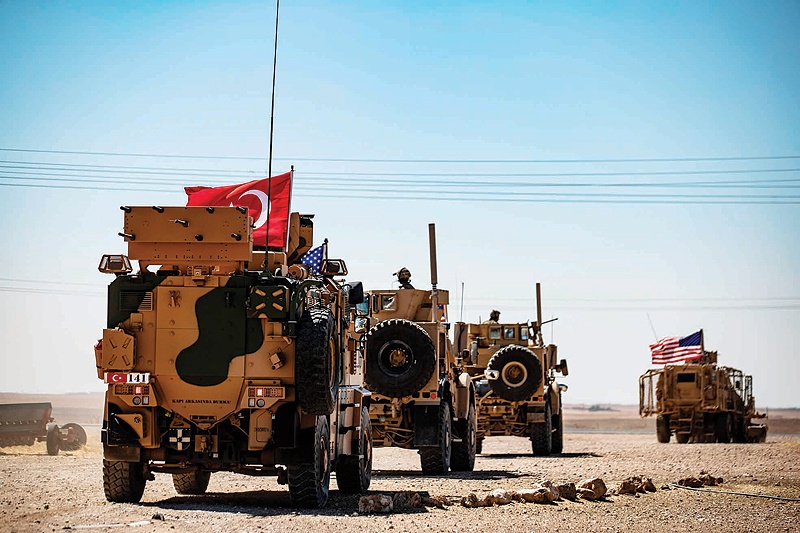 TAL ABYAD, Syria: Turkish and US military vehicles drive on a joint patrol in the Syrian village of Al-Hashisha on the border with Turkey yesterday. - AFP 