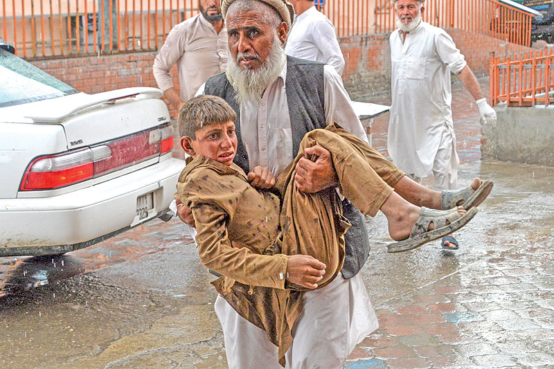 JALALABAD: A volunteer carries an injured youth to hospital, following a bomb blast in Haska Mina district of Nangarhar Province. — AFP