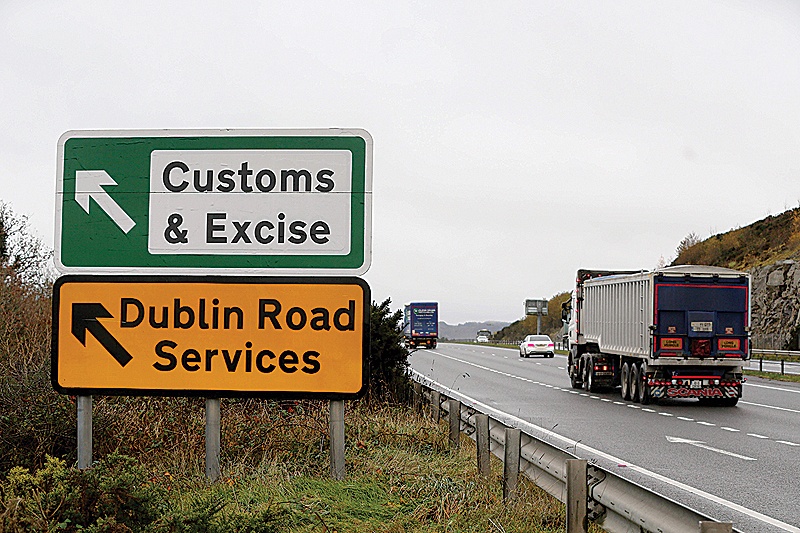 NEWRY: A lorry is seen passing a sign on a main road outside Newry, Northern Ireland, pointing towards an old customs and excise station near the border between Northern Ireland and Ireland. —AFP