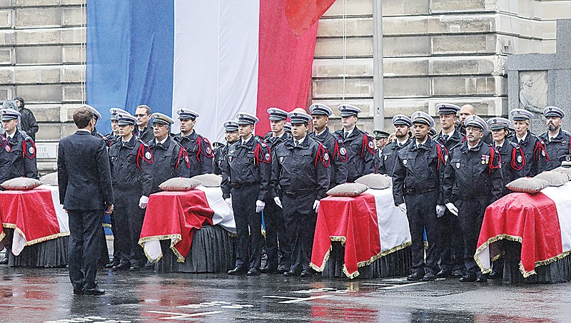 PARIS: French President Emmanuel Macron stands in front of coffins during a ceremony at The Prefecture de Police de Paris (Paris Police Headquarters), held to pay respects to the victims of an attack at the prefecture. —AFP