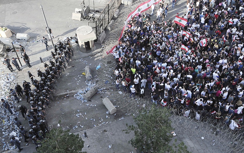 Lebanese security forces block a road as protesters rally in downtown Beirut, on the third day of demonstrations against tax increases and official corruption, on October 19, 2019. - Thousands of protesters outraged by corruption and proposed tax hikes burned tyres and blocked major highways in Lebanon on Friday, prompting the premier to give his government partners three days to support a reform drive. (Photo by ANWAR AMRO / AFP)